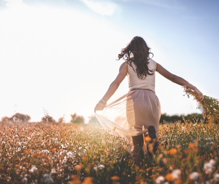 Calm woman taking a deep breath outdoors practising nervous system regulation and mindful breathing.